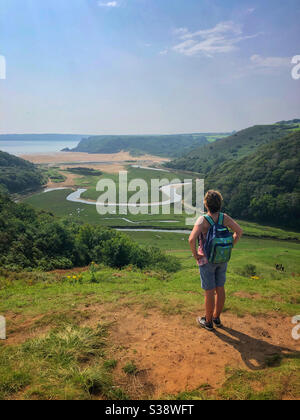 Middle aged woman enjoying the view from Pennard castle, Three Cliffs Bay, Gower, Swansea, Wales, August. Stock Photo