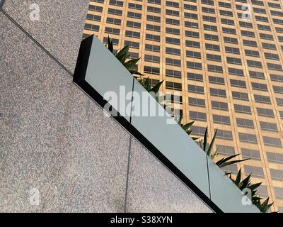 LOS ANGELES, CA, JUN 2020: abstract detail of office tower windows at Wells Fargo Center in the financial district of Downtown with marble wall and planters in foreground Stock Photo
