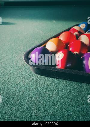Pool balls racked on a green pool table. Stock Photo