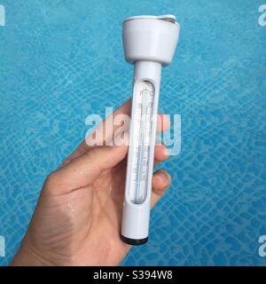 Reading a water thermometer in swimming pool, checking water temperature  Stock Photo - Alamy