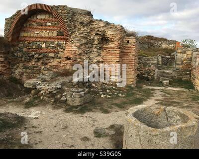 Brick wall and well in the Ancient Greek and Roman settlement at Histria Dobrogea Romania Stock Photo