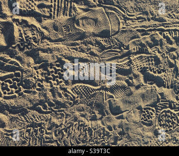 Sneaker and running shoe prints in sand on a jogging path along a beach Stock Photo