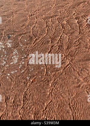 Patterns in the ocean water at the beach, tiny dots of sunlight dancing on the waters surface creating ripples Stock Photo