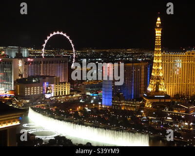 Bellagio fountains at night in Las Vegas, high view point with Eiffel Tower and the Wheel in view Stock Photo