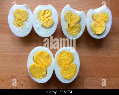 Three double yoke boiled chicken eggs cut in half in a row. Stock Photo