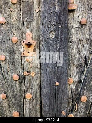 Old weathered studded oak door with rusty iron latch. Stock Photo