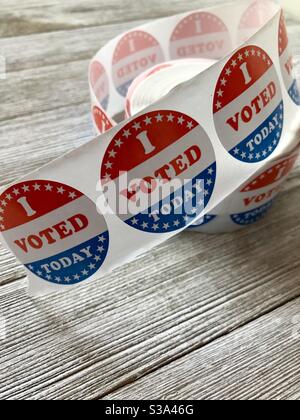 Roll of I voted stickers on a wooden table Stock Photo