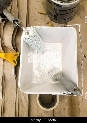 Paint brush and roller in a pot of paint. Stock Photo