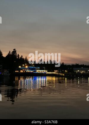 Tides Tavern reflecting across the water in Gig Harbor WA on a quiet Fall evening Stock Photo
