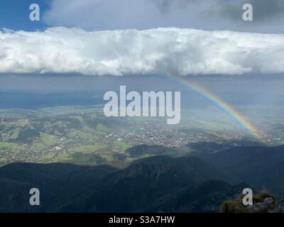 Picture taken from the top of Polish mountain top called “Giewont” In southern Portland in the Tatar in Mountains. Beautiful picture taken at the right time from rainbow coming down from the clouds. Stock Photo