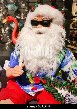 Decorative statue of cool Santa surfer dude with pink flamingos, Christmas time, United States Stock Photo