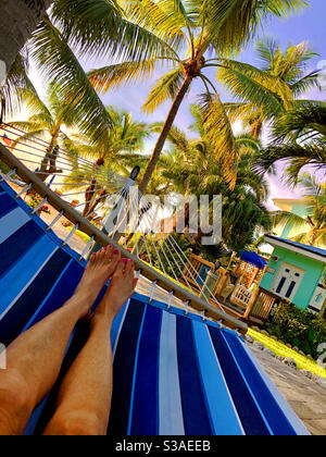 View from a woman relaxing on a hammock and looking toward the beach and palm trees in Key Largo, Florida. Stock Photo