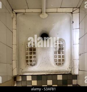 Traditional “Turkish” squat toilet in old French café - Bourges, France. Stock Photo