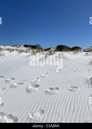 White sand dunes on Fort Walton Florida public beach with deep footprints in the sand Stock Photo