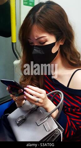 a fashionable hong kong chinese woman wearing a fashionable protective mask. Stock Photo