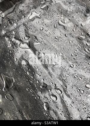 Rainwater collecting on plastic covered café table. Stock Photo