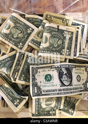 Pile of money in tip jar or box to collect tips. US paper dollar bills Stock Photo