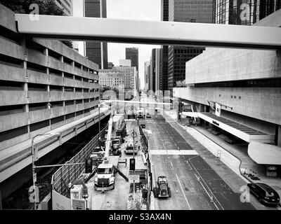 LOS ANGELES, CA, JUL 2020: looking south along Flower Street, with LA Metro new rail construction in foreground. Parking structure on left and pedestrian bridges cross the street. Black and white Stock Photo