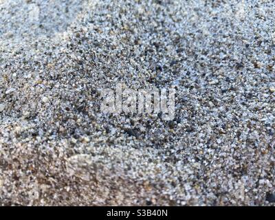 Shallow focus macro view of sand grains on a beach in shadow Stock Photo