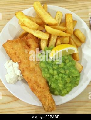 A plate of fish, chips and mushy peas. Stock Photo