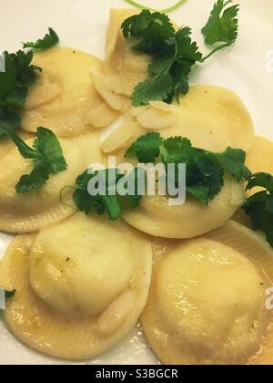 Close up of a gourmet Italian entrée of lemon ravioli with almonds and cilantro. Stock Photo