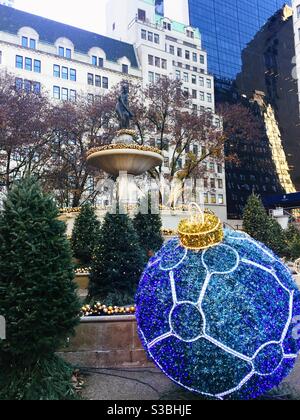 Pulitzer fountain outside of the Plaza Hotel in the grand Army Plaza features outsized Christmas ornaments and Christmas tree decorations during the holiday season Stock Photo