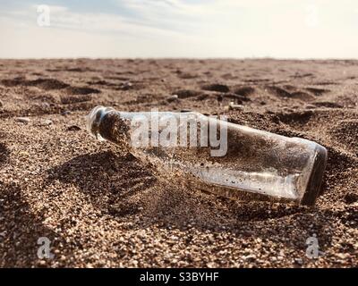 Empty bottle left on beach Stock Photo