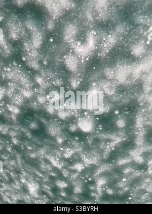 Abstract background of emerald colored soap suds on a car windshield Stock Photo