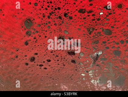 Abstract background of red soapy suds on a car windshield Stock Photo