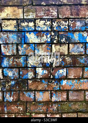 Old brick wall with layers of peeling and faded paint. Stock Photo