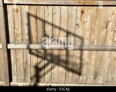 Shadow of a basketball hoop on a wooden fence Stock Photo