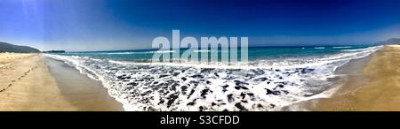 Pano of Patara Beach, Turkey with the gentle Mediterranean Sea waves lapping gently along the sandy shore on a hot summer holiday day Stock Photo