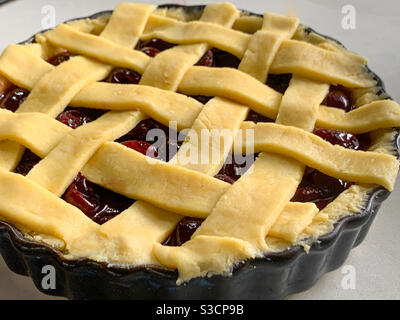 Lattice topped cherry pie ready to bake, homemade food saves money Stock Photo