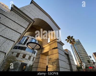 LOS ANGELES, CA, NOV 2020: angled view, detail of entrance arch at the Wedbush Building, illuminated by golden light from setting sun in Downtown Stock Photo