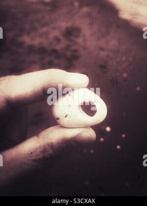 Man holding a stone with a hole In it Stock Photo
