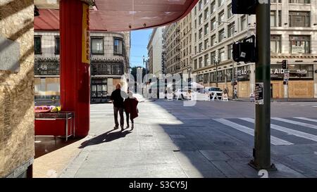 LOS ANGELES, CA, NOV 2020: silhouetted couple walking towards open air farmers market during Covid-19 pandemic in Downtown on a Sunday morning Stock Photo