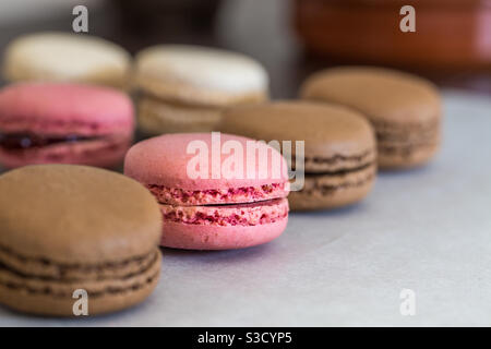 A close-up of a row of chocolate and strawberry macaroons with copy space Stock Photo