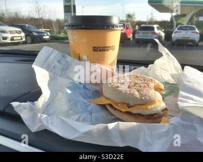 Taking a rest. McDonald’s drive thru, take away breakfast Egg McMuffin and coffee on the car dashboard. UK Stock Photo