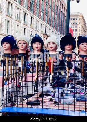 A row of mannequin heads model winter hats at a street vendor stand on 34th St. in Midtown Manhattan, New York, USA Stock Photo