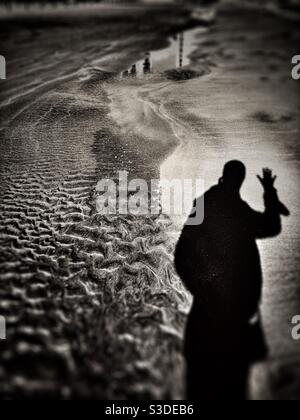 Dramatic image of shadow of a man on beach Stock Photo