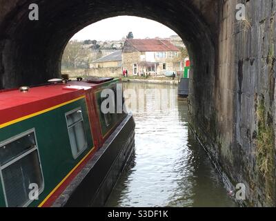 Green and red canal boat going through a tunnel on the Bradford-upon-Avon canal, England, UK Stock Photo