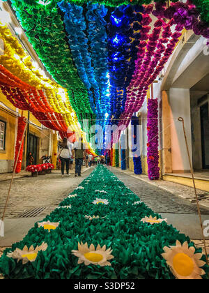 People walk down a colourful, decorated street in Tomar, Portugal, 2019. Festa dos Tabuleiros Stock Photo