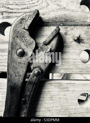 Well used Self Grip Wrench On a wooden workbench Stock Photo