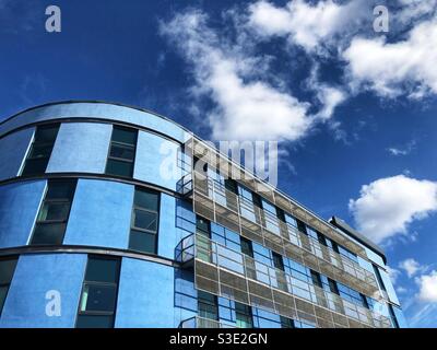 A colourful contemporary apartment building with curved facade painted a pastel sky blue colour Stock Photo