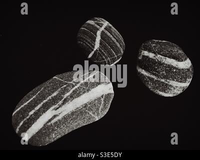 Three pieces of  stripy rocks photographed on black background Stock Photo