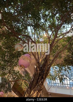 Looking up at an indoor tree decorated with hanging Easter eggs Stock Photo