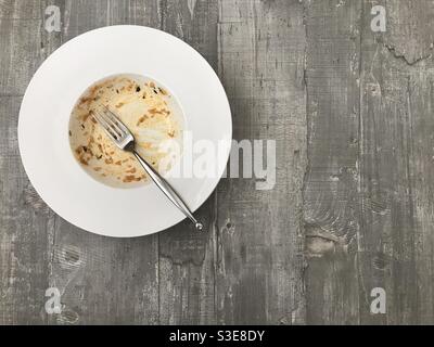 Empty bowl of rice against a wooden background Stock Photo