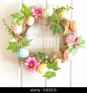 A colourful Easter door wreath with Easter eggs and spring flowers on a white background Stock Photo