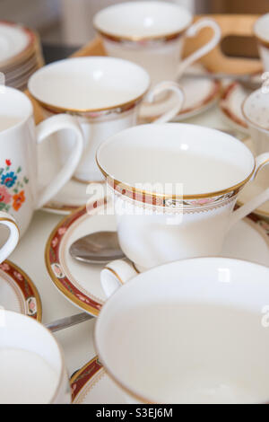 Rows of empty bone china vintage English tea cups and sources on a café tray Stock Photo