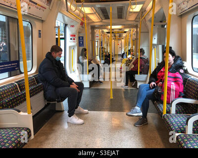 People onboard a District Line train in The London Underground wear face masks as a precaution due to coronavirus. Stock Photo